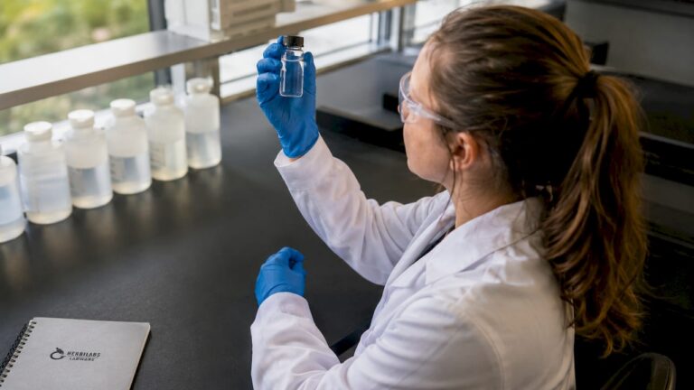 Lab technician inspecting bacteriostatic water vial