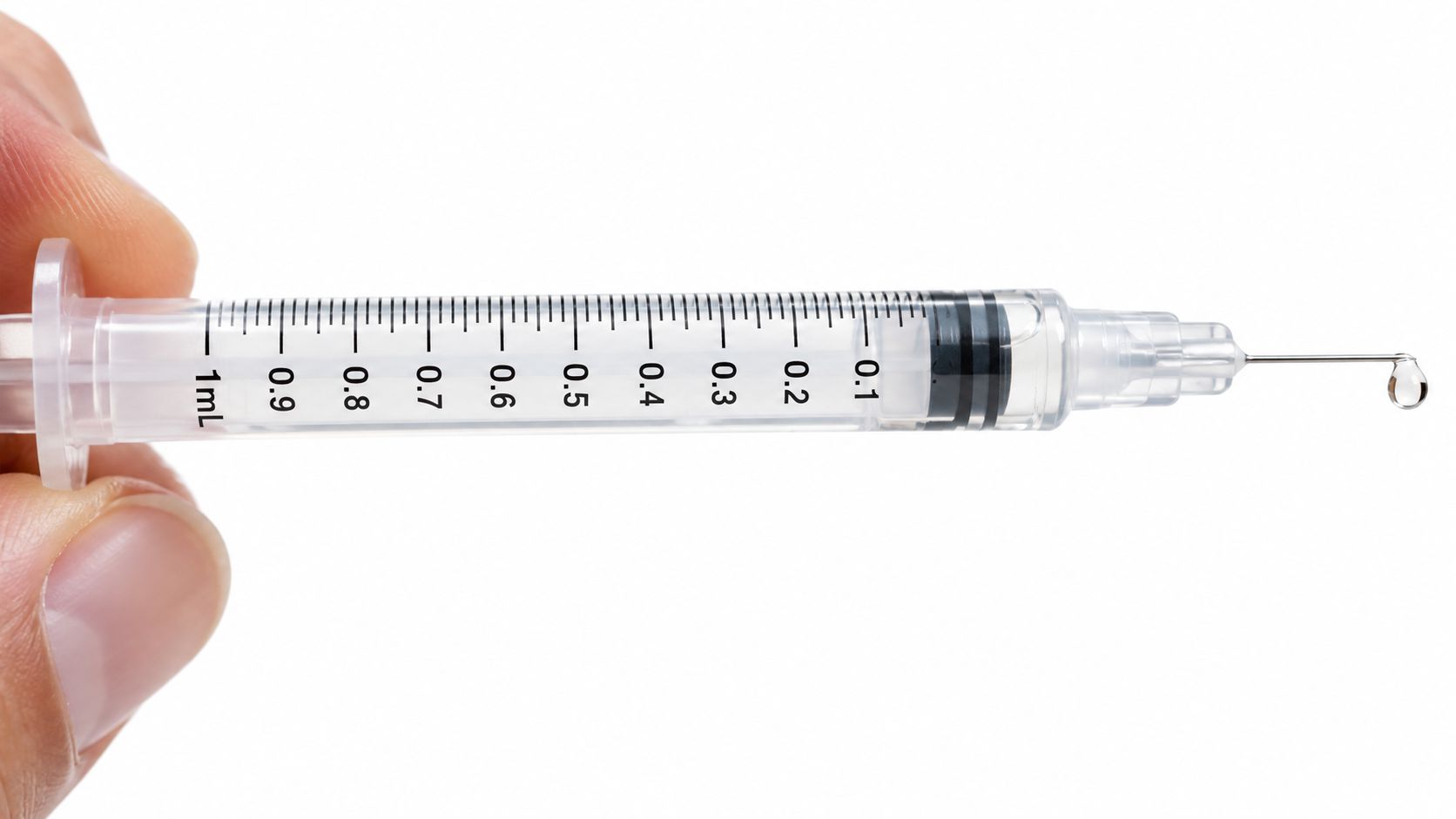 A close-up view of a medical syringe being held, showing the 1ml graduation mark and a drop of liquid.